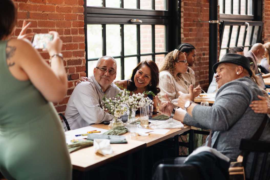 family member admiring aonther family member, taking pictures of her dad on her cellphone