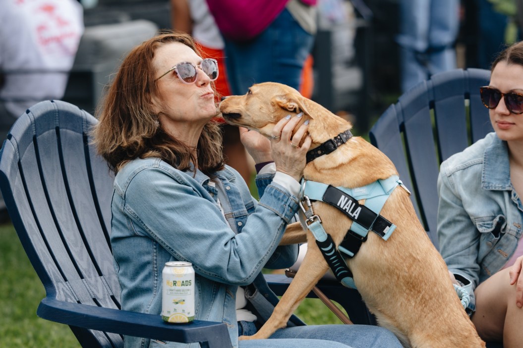 photo of a woman embracing her dog at stratford, two roads brewery event "paws and pints"
